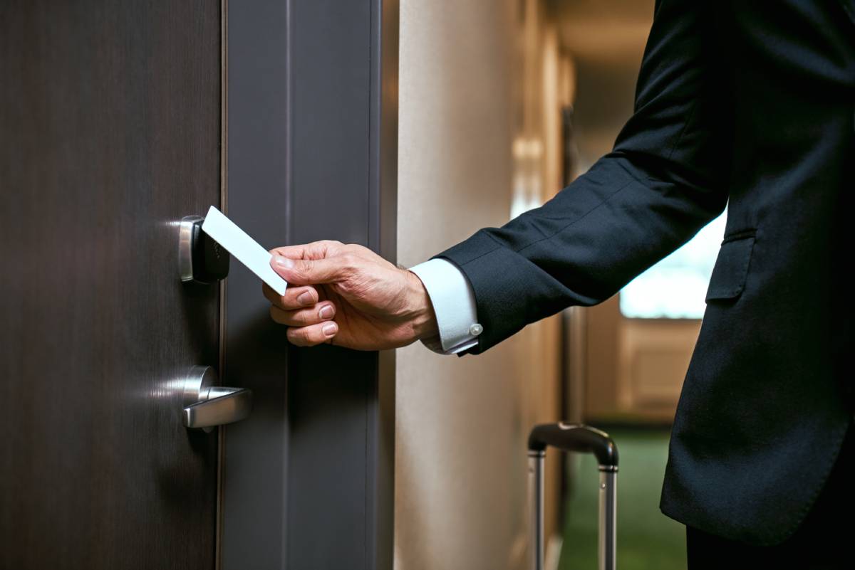A hotel employee opening a door with a key card