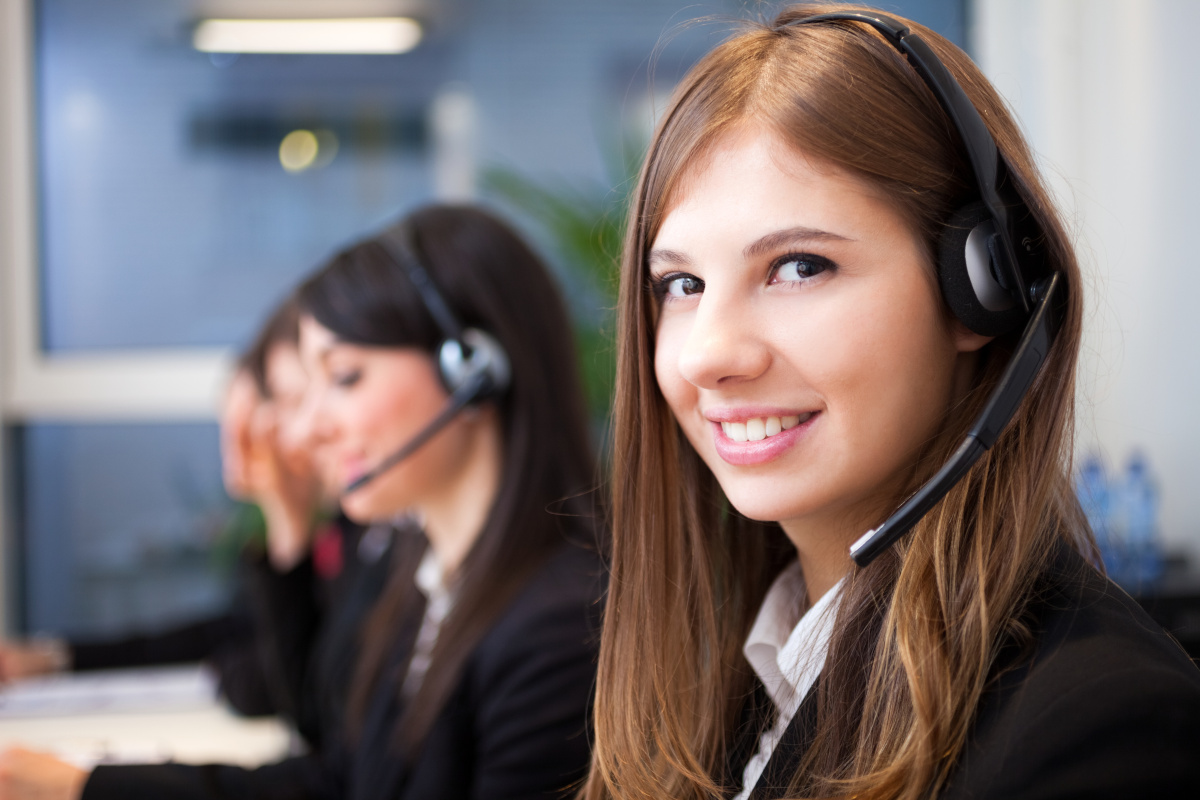 A group of employees each at their workstation with headsets answering work calls