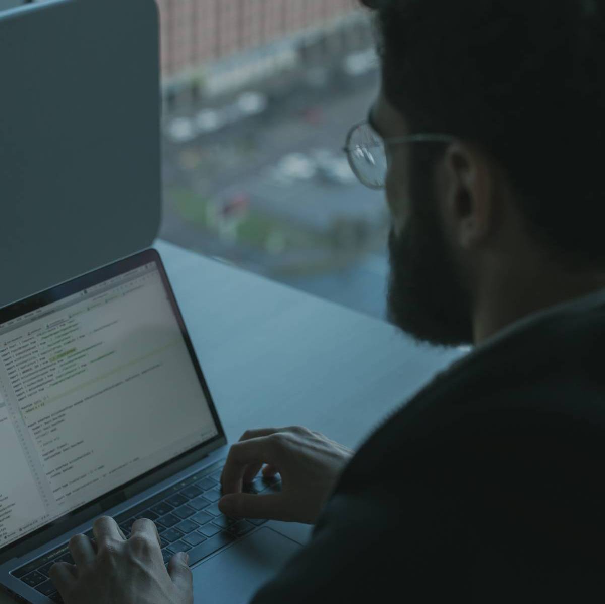 A man sitting at a desk working on his laptop