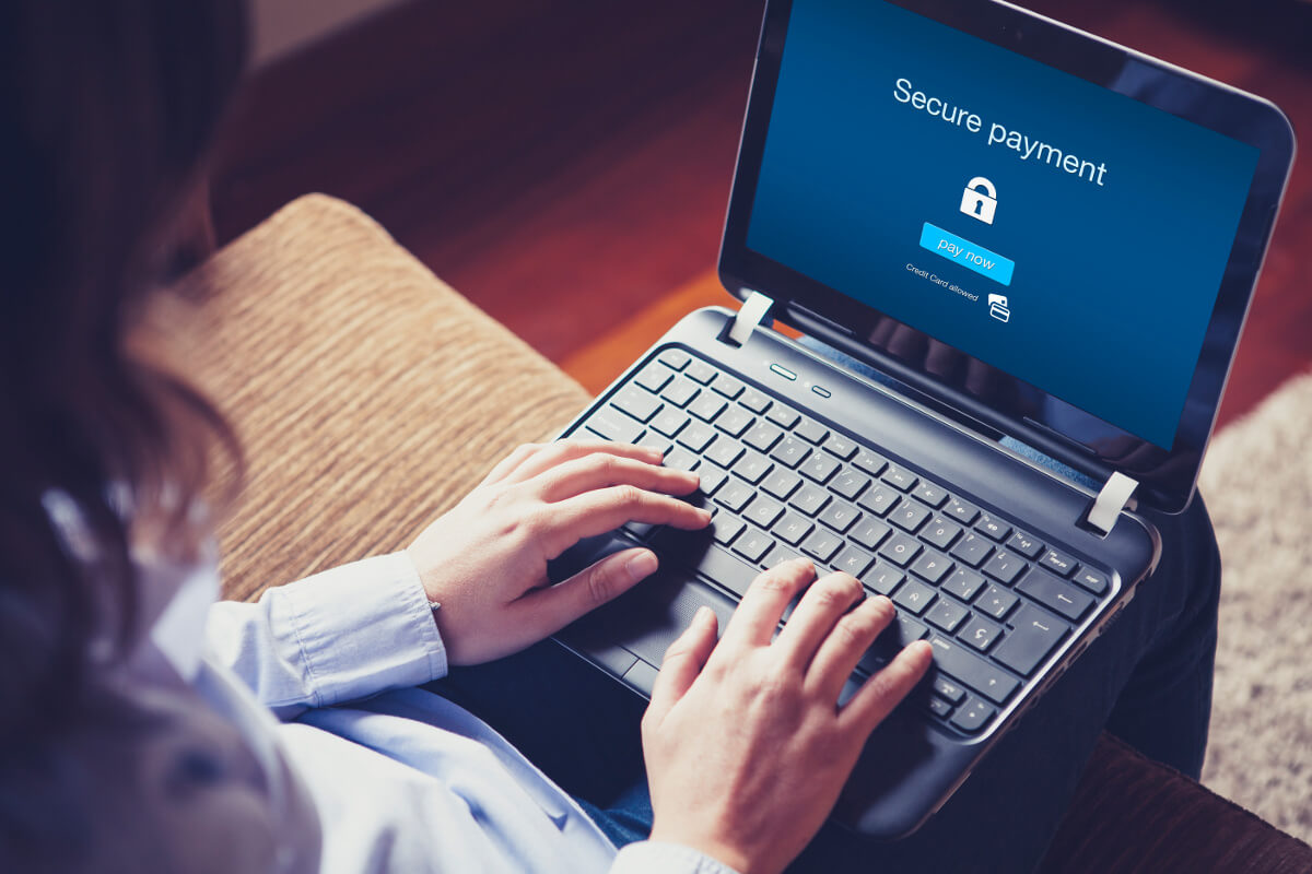 Woman Sitting in Front of Secure Payment Message on a Laptop Screen