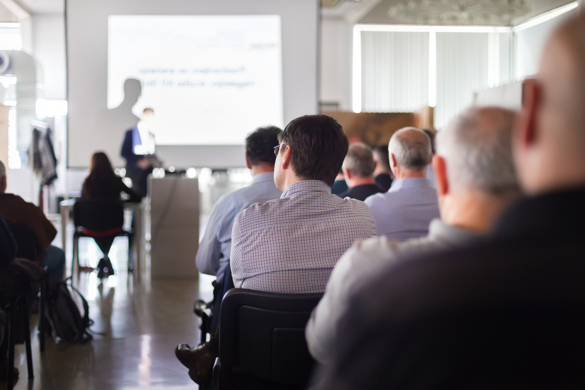 A presentation being given to a large audience at an event.