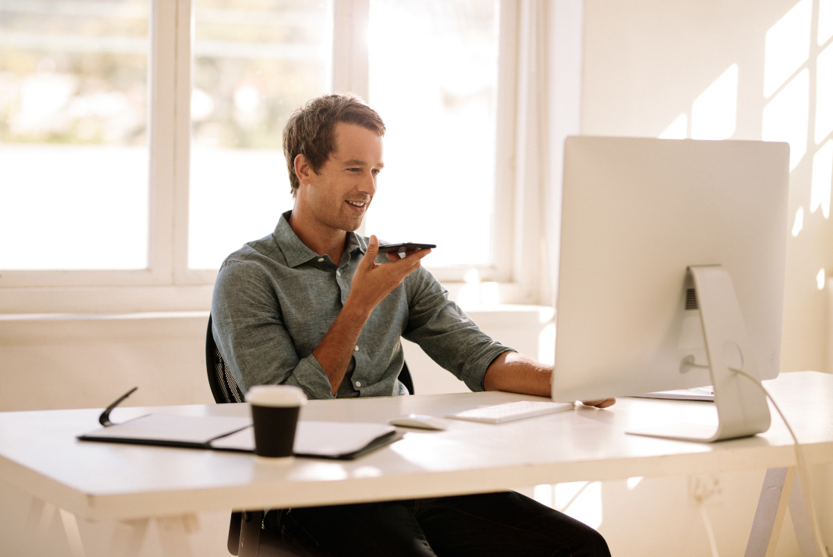 A man working from his home office while talking on a cell phone