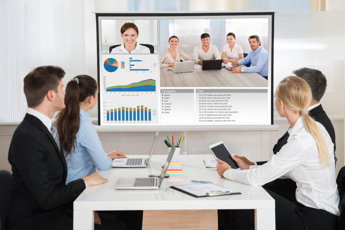 Colleagues having a video conference with employees in a satellite office